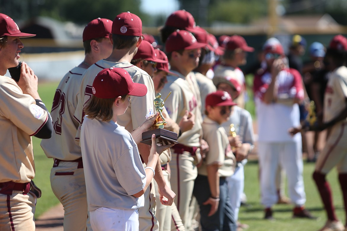 An Alabama bat boy looks on at the first place trophy received for winning the World Series.