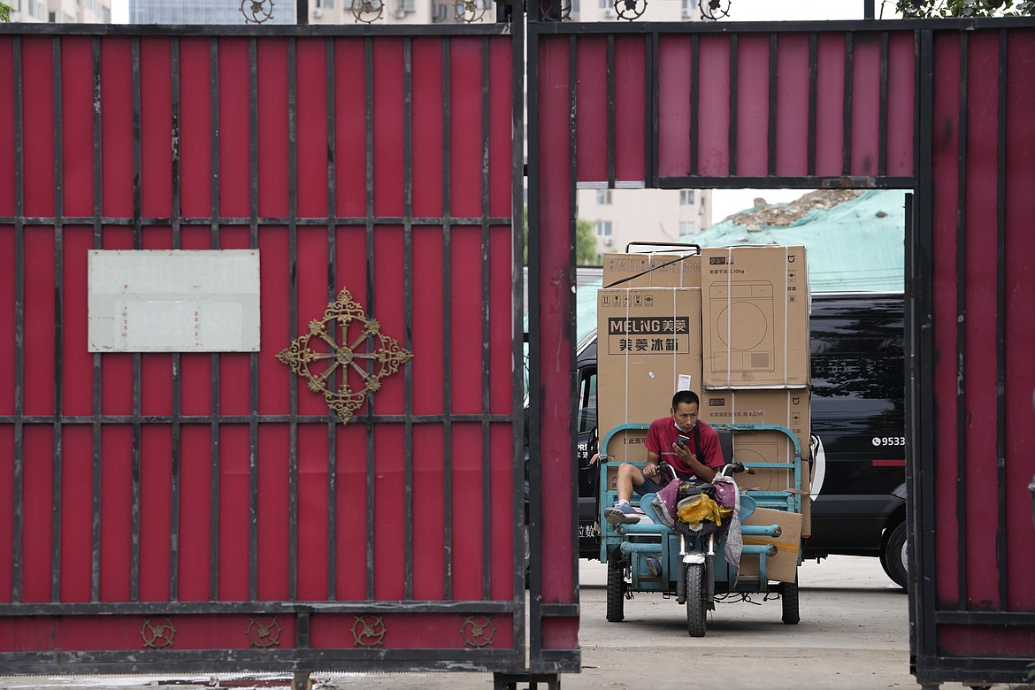 A delivery man transports home appliances from a delivery hub in Beijing, Monday, Aug. 15, 2022. China’s central bank trimmed a key interest rate Monday to shore up sagging economic growth at a politically sensitive time when President Xi Jinping is believed to be trying to extend his hold on power. (AP Photo/Ng Han Guan)