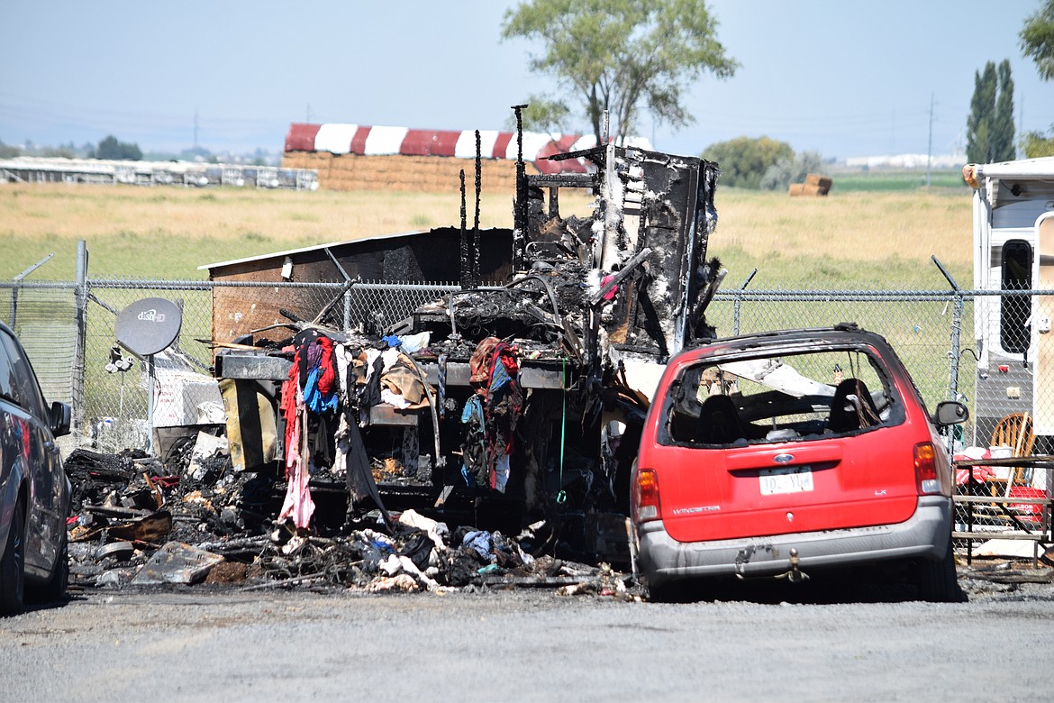 The remnants of a camper trailer where the remains of two people were found following an early Monday fire.