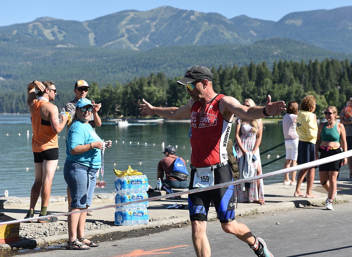 Matthew Weller of Kalispell soars through the finish line at the Whitefish Lake Triathlon on Sunday. (Whitney England/Whitefish Pilot)