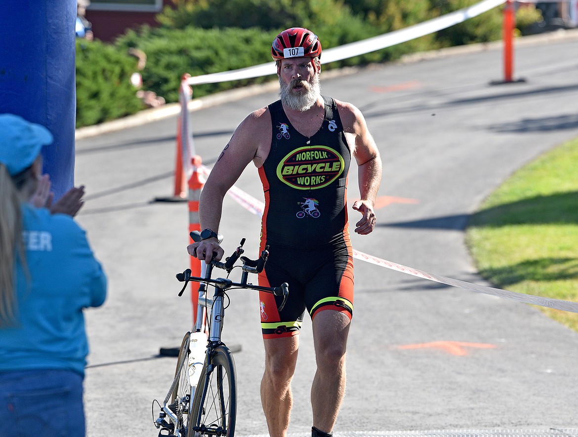 Paul Flannigan of Whitefish transitions from cycling to the running section of the Whitefish Lake Triathlon on Sunday, Aug. 14. (Whitney England/Whitefish Pilot)