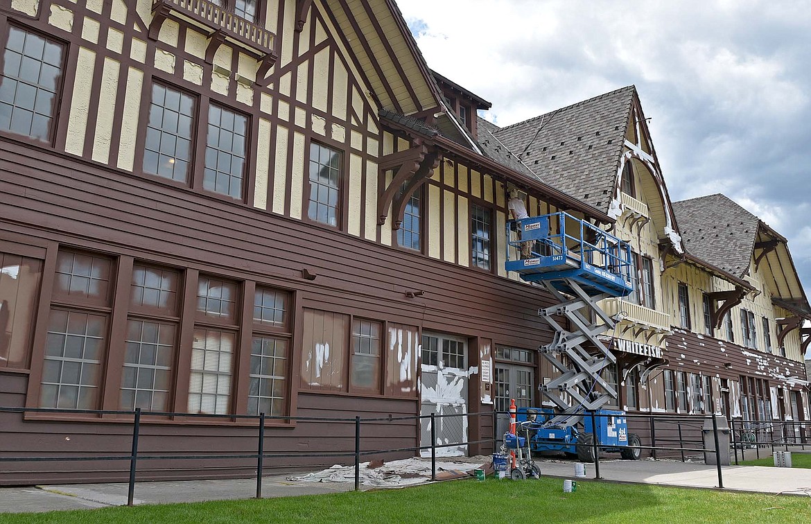 A painter gives the historic Whitefish Depot a fresh coat of paint last month. (Whitney England/Whitefish Pilot)