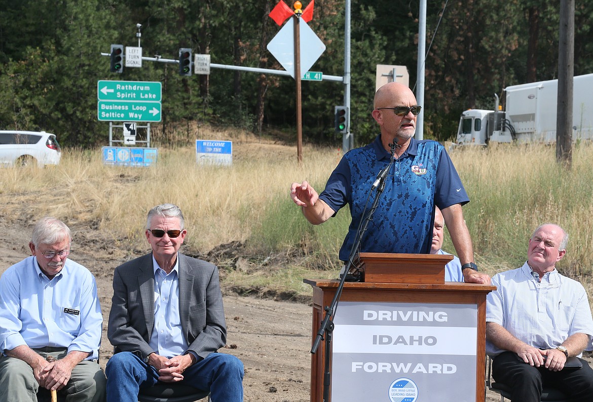 Post Falls Mayor Ron Jacobson speaks during the Highway 41 and I-90 interchange groundbreaking ceremony as traffic roars at a busy intersection Tuesday afternoon. Also pictured, from left: Idaho Transportation Board District 1 representative Jim Thompson, Gov. Brad Little, ITD Director Scott Stokes (behind Jacobson) and Rep. Jim Addis, R-Coeur d'Alene, who serves on the Transportation and Defense Committee.