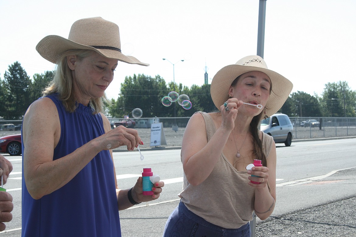 Bubbles filled the air during the dedication of the last mural in the “Pieced Together” project Tuesday. Leslie Ramsden (left) and Shawn Cardwell (right) do the honors.