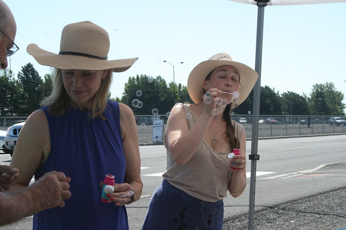 Leslie Ramsden (left) and Shawn Cardwell (right) add a few bubbles to the celebration during the dedication of the last mural in the “Pieced Together” project.