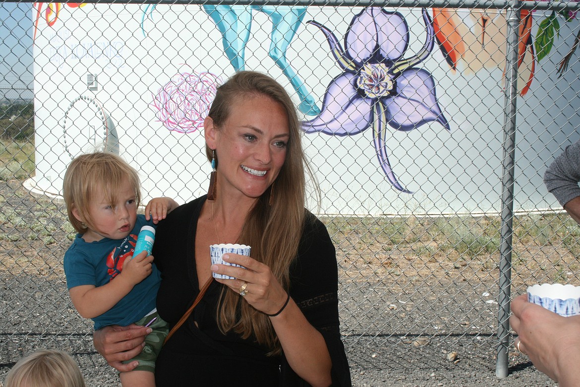 Erika Kovalenko and her son Konan raise a glass of sparkling cider in celebration of the completion of the “Pieced Together” mural project.