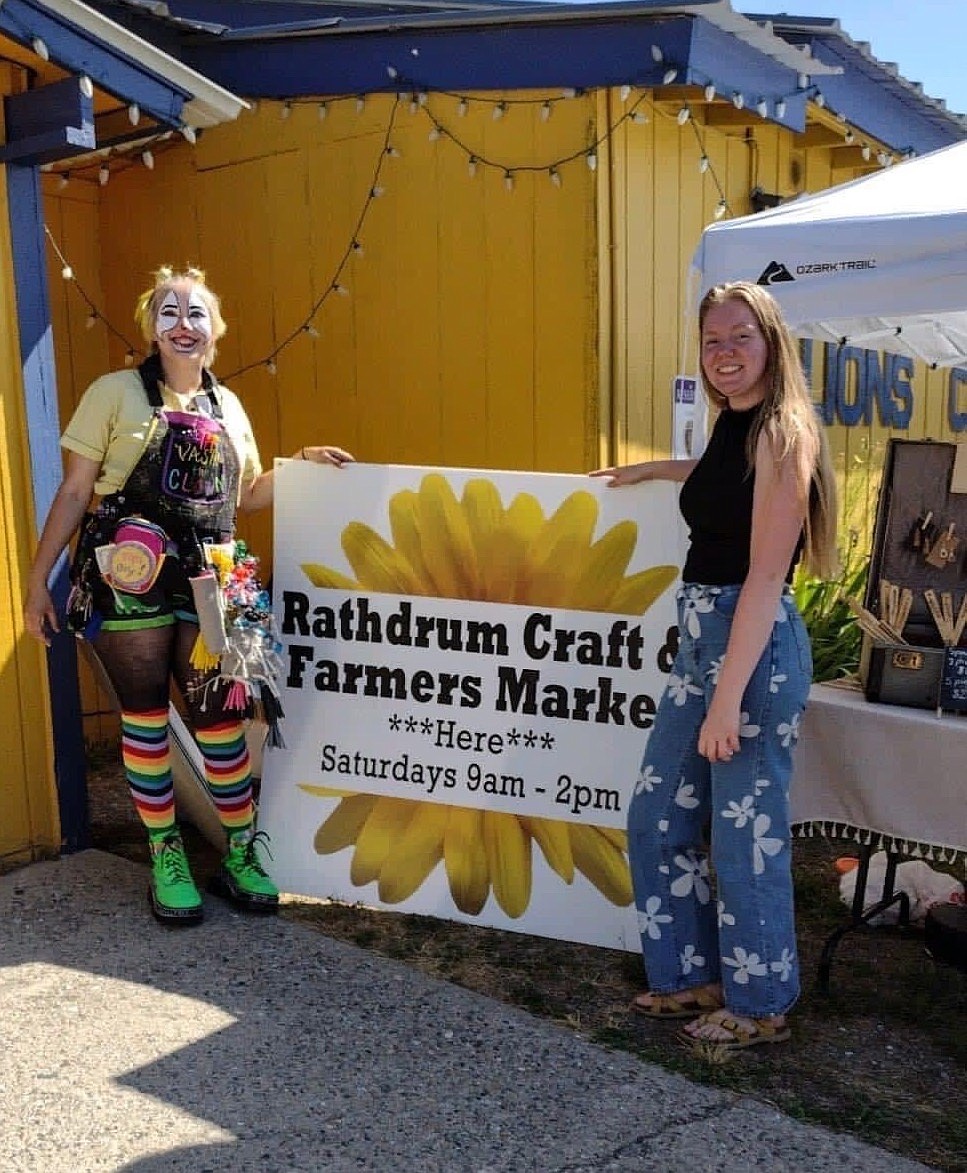 Rathdrum Craft and Farmers Market member Vastra the Clown (Violet Hammond) and treasurer Sofia Rhoades of On_the_white_walls are seen at the market July 30. The market recently received its nonprofit status and moved to the Rathdrum Lions Clubhouse, where it will partner with the Lions Club on different projects.