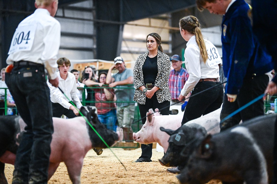 Judge Mari Morris watches contestants guide their pigs around the arena during senior swine showmanship at the Northwest Montana Fair on Wednesday, Aug. 17. (Casey Kreider/Daily Inter Lake)