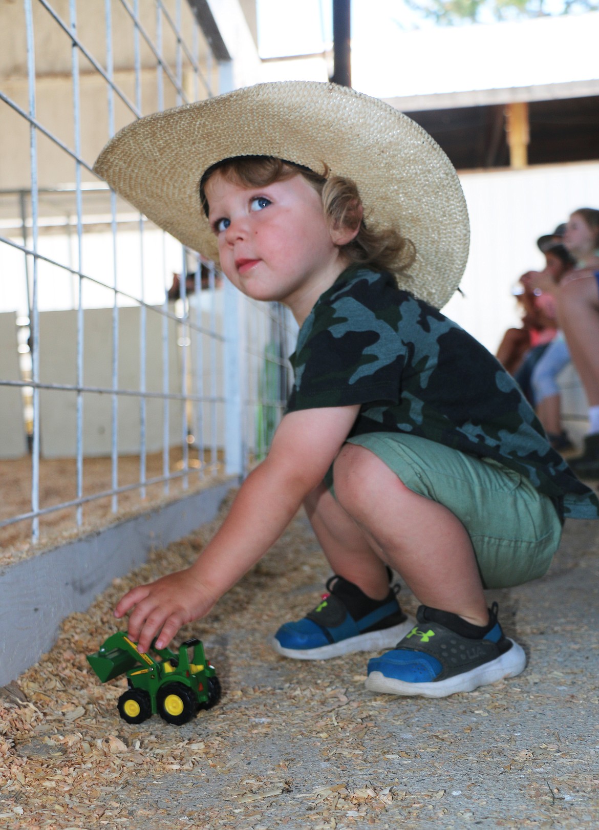 Zeke Schoonover plays with his tractor while family members watch a swine competition at the Bonner County Fair on Tuesday. He is the son of Libby and Isaac Schoonover of Sandpoint.