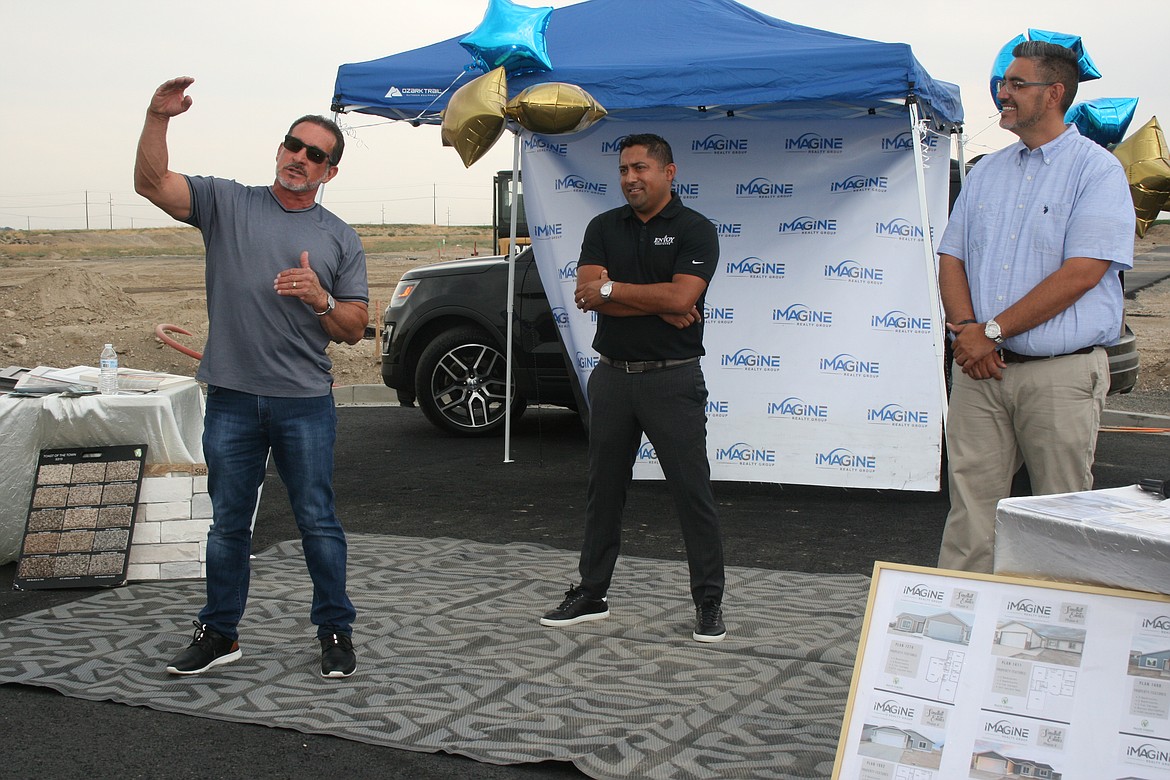 Angel Garza (left) developer for Sandhill Estates (left) talks about the project during a ribbon cutting for the fourth phase. Miguel Velasquez, Envoy Mortgage (center) and Jessie Dominguez of Imagine Realty (right) look on.