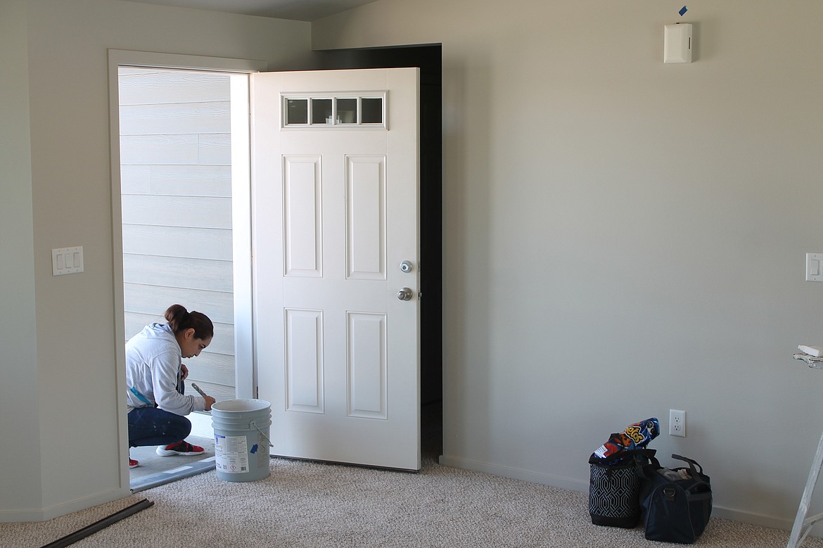 Maria Tapia does the finishing work on a door built in the third phase of the Sandhill Estates development.