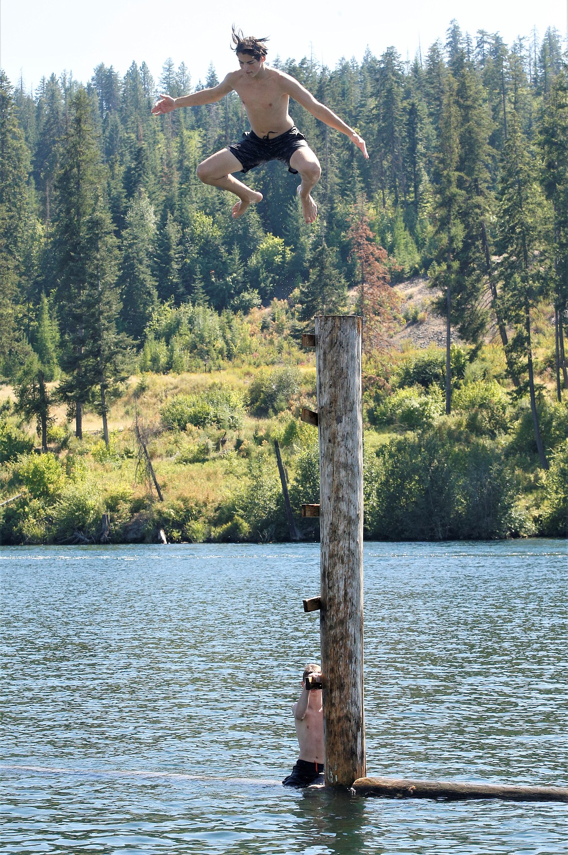 Zachariah Graves leaps high as he heads for the Spokane River at Atlas Waterfront Park on Wednesday.