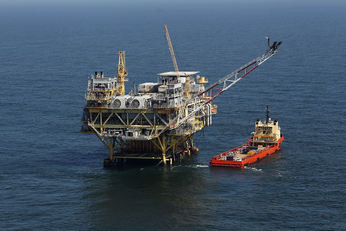 FILE - A rig and supply vessel are pictured in the Gulf of Mexico, off the cost of Louisiana on April 10, 2011. A judge’s order that forced the Biden administration to resume sales of oil and gas leases on federal land and waters was vacated on Wednesday, Aug. 17, 2022, by a federal appeals court in New Orleans. (AP Photo/Gerald Herbert, File)