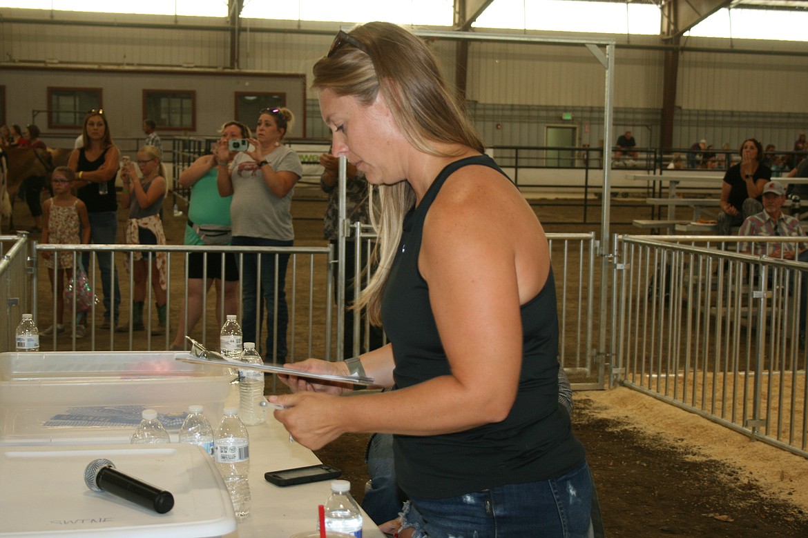 Jessica Chamberlain looks over the contestant list in the swine market class competition Wednesday at the Grant County Fair. Chamberlain said she’s been a fair volunteer for a couple of years.