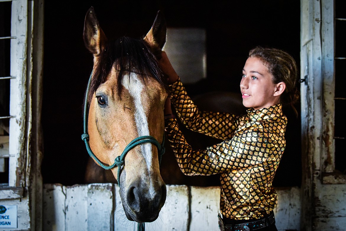 Kadence Corrigan tends to her horse Chewy inside one of the horse barns at the Northwest Montana Fair on Saturday, Aug. 13. (Casey Kreider/Daily Inter Lake)