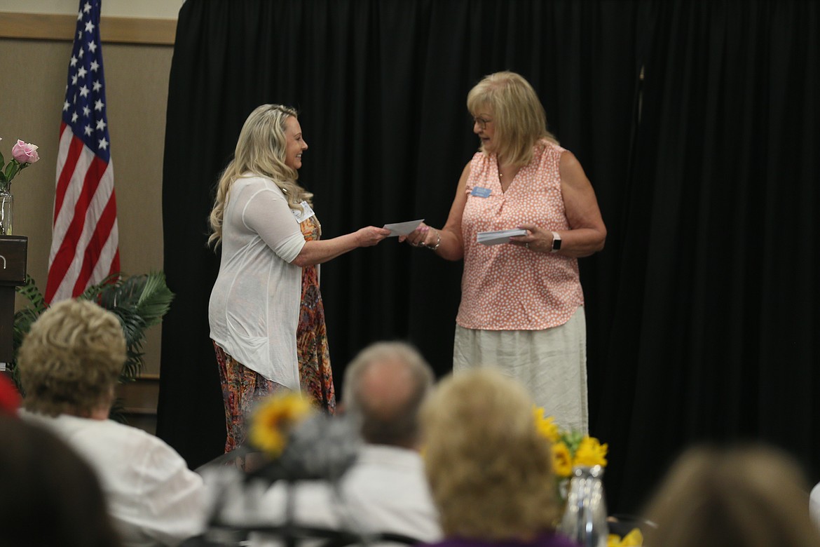 Laura Sanborn with Hospice of North Idaho accepts a grant check from incoming Cancer and Community Charities President Ann Dare on Friday during the annual 3Cs Appreciation Lunch.