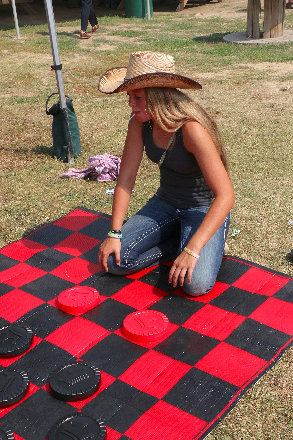 Zoe Hunt ponders her next move as she plays a game of checkers with a friend at the Bonner County Fair on Friday.
