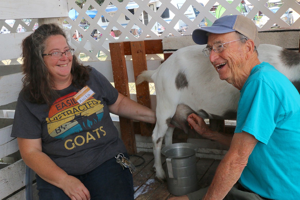 Anita Palmer, left, smiles at the delight shown by a fairgoer who decided to try his hand at milking a goat on Friday. The Bonner County Fair wraps up today with a full slate of activities.