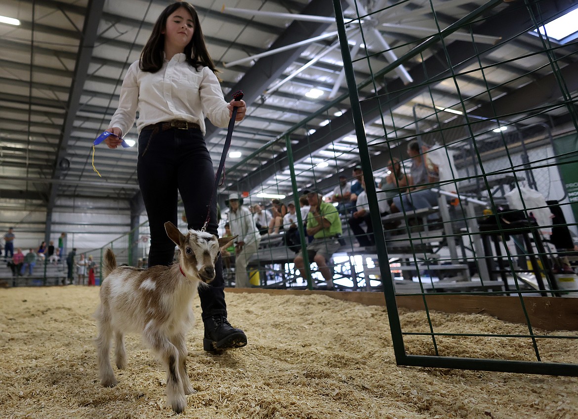 Gwyndolyn Russell exits the show ring with her five-week old goat at the Northwest Montana Fair in Kalispell Aug. 18. (Jeremy Weber/Daily Inter Lake)