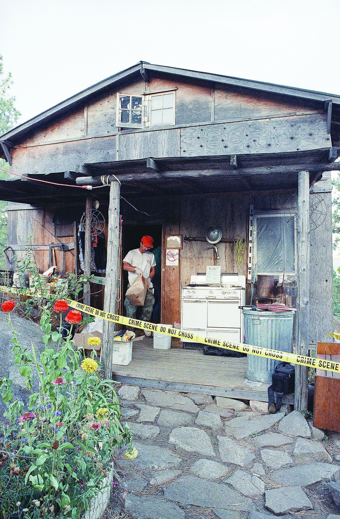 In this Aug. 31, 1992, file photo, federal agents gather evidence from the home of captured fugitive Randy Weaver near Naples, Idaho. It's been a quarter century since a standoff in the remote mountains of northern Idaho left a 14-year-old boy, his mother and a federal agent dead and sparked the expansion of radical right-wing groups across the country that continues to this day.