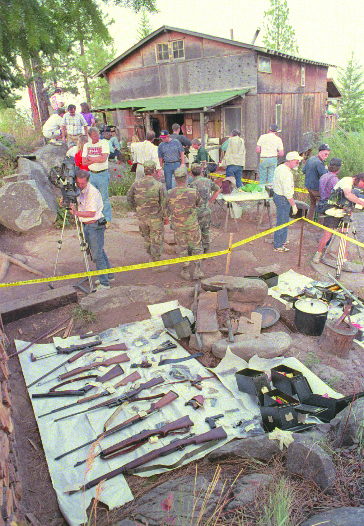 n this Sept. 1, 1992, file photo, media members and federal agents tour the outside of Randy Weaver's home near Naples, Idaho.It's been a quarter century since a standoff in the remote mountains of northern Idaho left a 14-year-old boy, his mother and a federal agent dead and sparked the expansion of radical right-wing groups across the country that continues to this day.