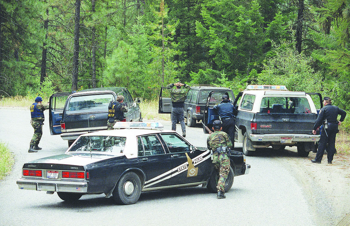 With guns drawn, agents of the Bureau of Alcohol Tobacco and Firearms and the Idaho State Patrol place the first of five neo-Nazis under arrest near Naples, Idaho, Aug. 25, 1992. Numerous weapons were found in the group's car (back, center) near a police barricade three miles from the site of a four-day standoff with white supremacist, Randy Weaver. The five will face weapons charges.