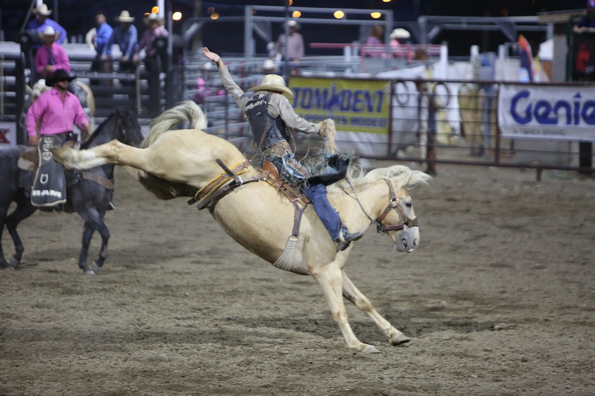 Riders in the saddle bronc event, known as the rodeo’s classic event, try to maintain balance atop a bucking horse.