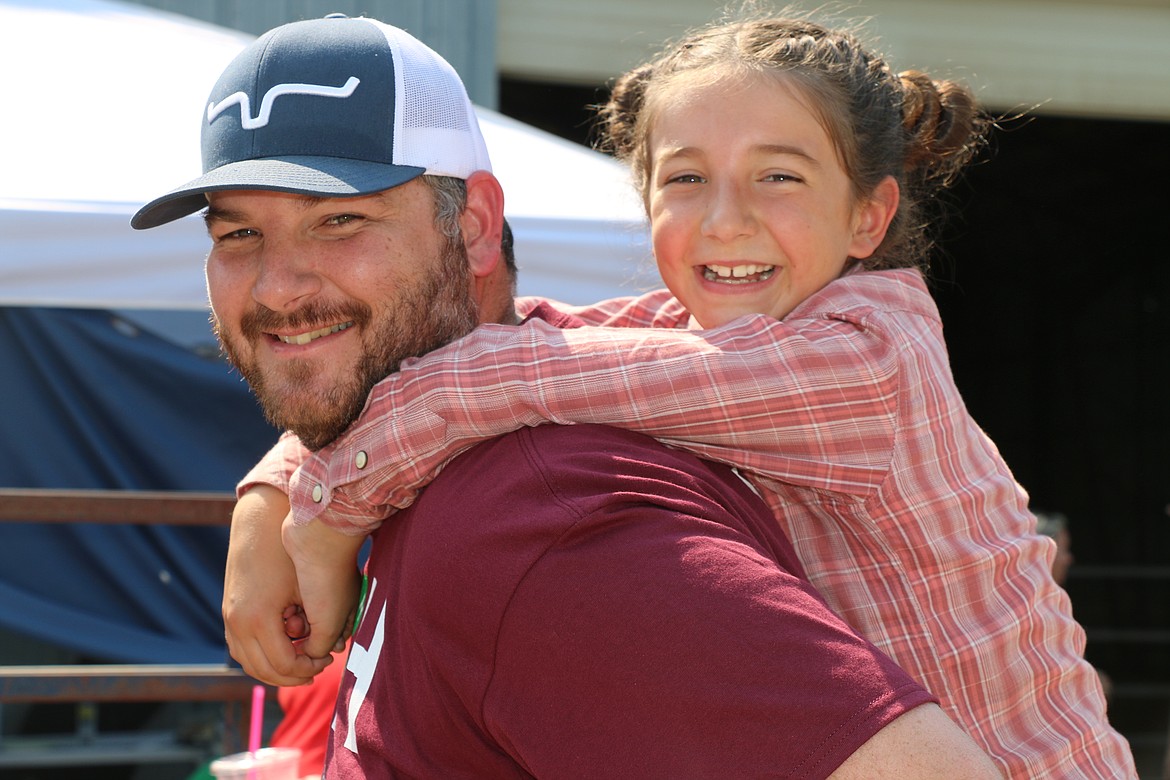 Maylie Spohn gets a piggyback ride from her dad, Zach Spohn, at the Bonner County Fair on Saturday.