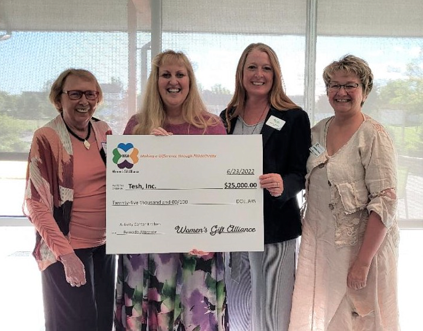 Women's Gift Alliance members Judy Salzer, far left, and Jeneane Prince, far right, present Tesh, Inc. Vice President Terri Johnson, center left, and CEO Marcee Hartzell with a $25,000 grant in June.