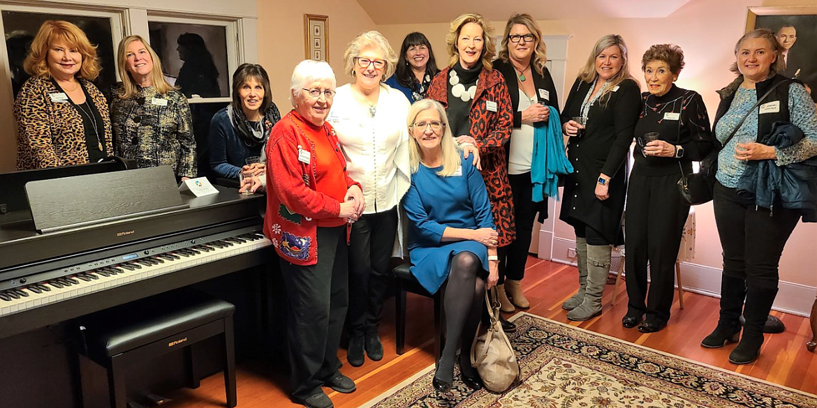 Women's Gift Alliance members gather around one of five new practice pianos that were purchased by the Music Conservatory of Coeur d'Alene with a Women's Gift Alliance grant in December 2021.