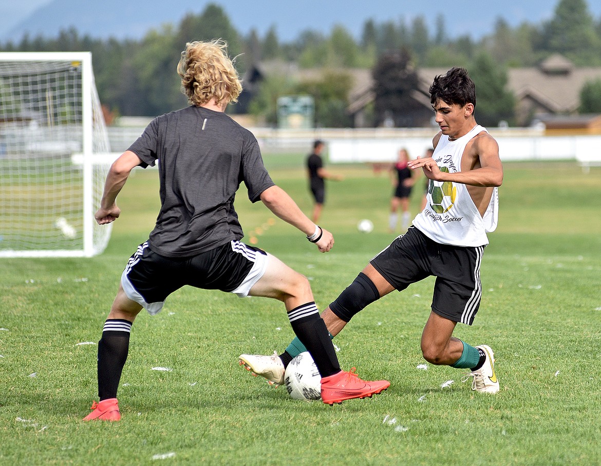 Bulldog Ramzi Maaliki works to get the ball around Jack Grant during a drill at practice on Monday. (Whitney England/Whitefish Pilot)