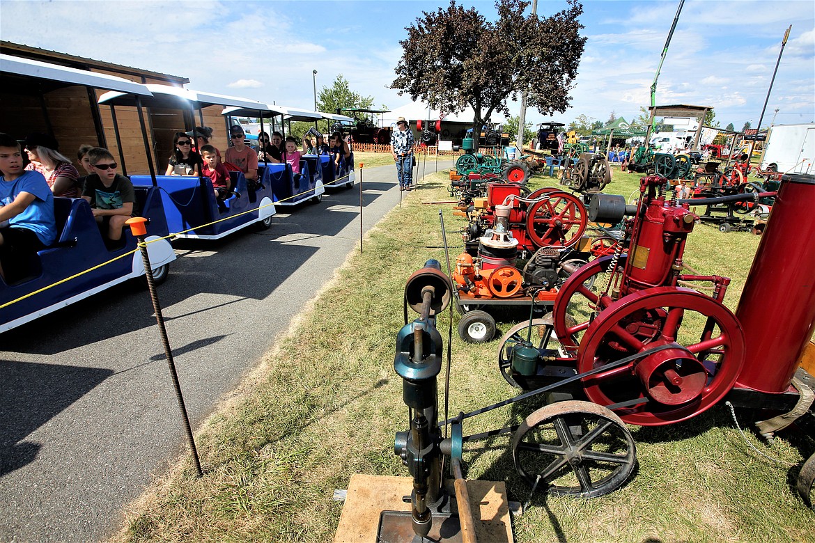 A passenger train at the North Idaho State Fair passes by Grandpa's Alley, where vintage agricultural equipment is on display Wednesday.