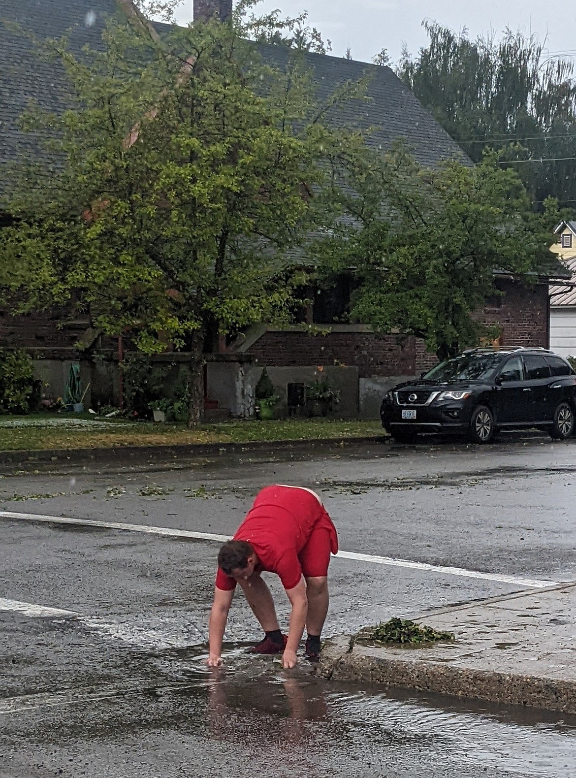 A Wallace resident attempts to clear a storm drain near the Post Office in Wallace.