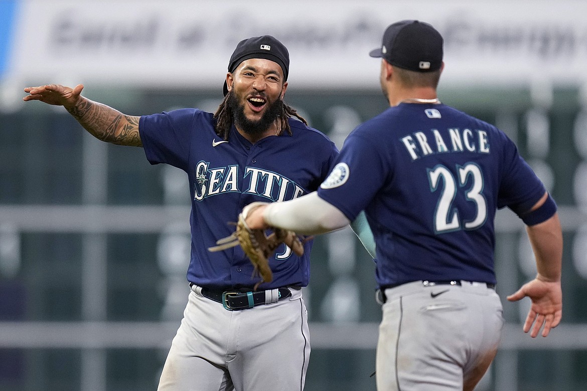 Seattle Mariners' J.P. Crawford, left, celebrates with Ty France the team's win over the Houston Astros in a baseball game, Saturday, July 30, 2022, in Houston.