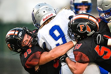 Flathead defenders Brandon Lewis (99) and Easton Casper (58) bring down Billings Skyview running back Hunter Sherner (9) in the third quarter at Legends Stadium on Friday, Aug. 26. (Casey Kreider/Daily Inter Lake)