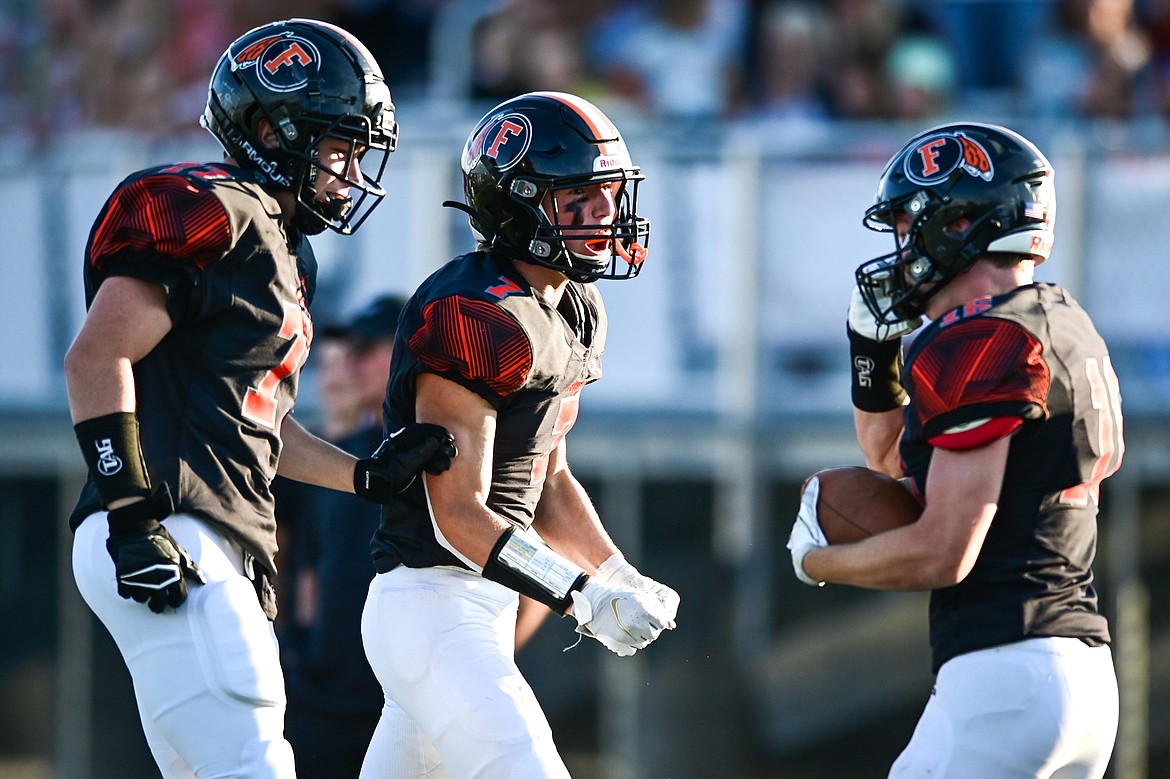 Flathead's Peyton Caudill (77), Stephen Riley (7) and Tanner Heichel (16) celebrate after Heichel recovered a fumble in the first half against Billings Skyview at Legends Stadium on Friday, Aug. 26. (Casey Kreider/Daily Inter Lake)