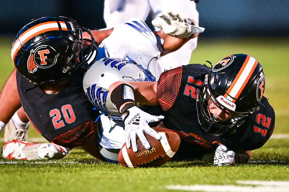Flathead defensive back Connor Skalsky (12) recovers a fumble caused by fellow defensive back Trevor Burke (20) in the fourth quarter against Billings Skyview at Legends Stadium on Friday, Aug. 26. (Casey Kreider/Daily Inter Lake)