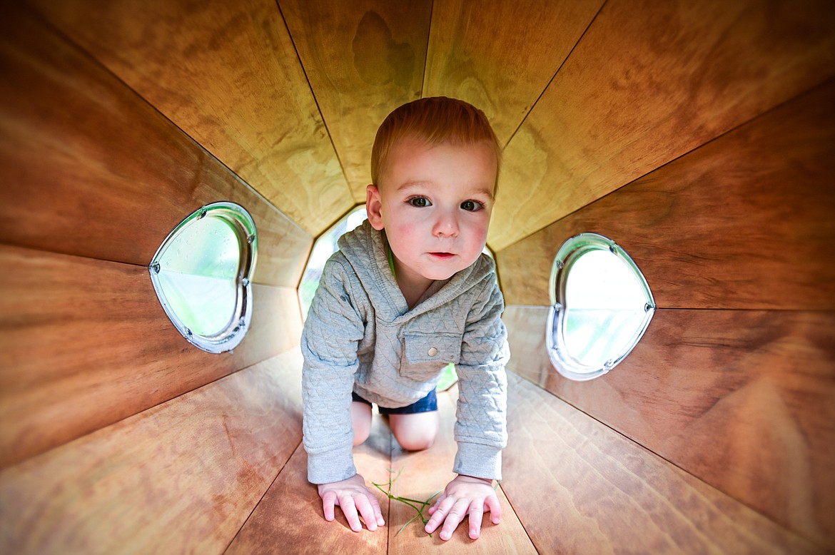 Wesson explores inside a playground tunnel outside the nursery school at The Birds Nest Early Learning Village in Kalispell on Friday, Aug. 26. (Casey Kreider/Daily Inter Lake)