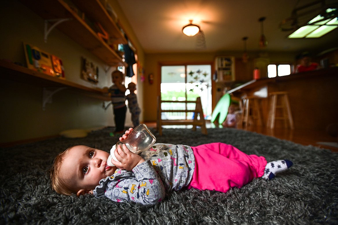 Hawna feeds on a bottle in a patch of sunlight inside the nursery school at The Birds Nest Early Learning Village in Kalispell on Friday, Aug. 26. (Casey Kreider/Daily Inter Lake)