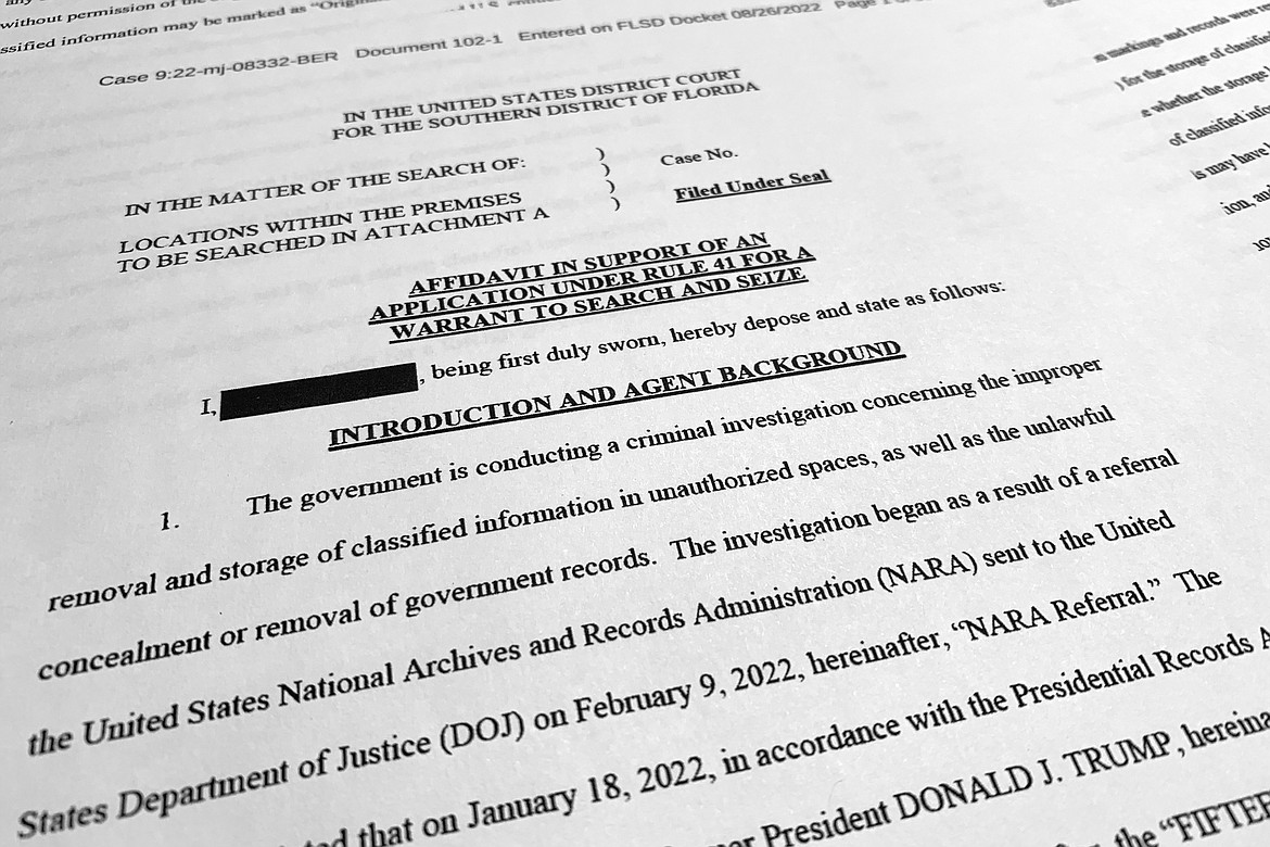 The affidavit by the FBI in support of obtaining a search warrant for former President Donald Trump's Mar-a-Lago estate is photographed Friday, Aug. 26, 2022. U.S. Magistrate Judge Bruce Reinhart ordered the Justice Department to make public a redacted version of the affidavit it relied on when federal agents searched Trump's estate to look for classified documents. (AP Photo/Jon Elswick)