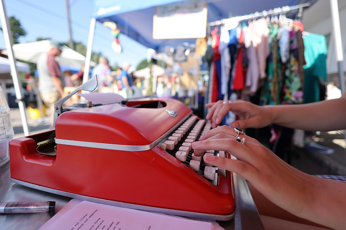 The hands of Paige Moriarity peck away at her typewriter as she prepares custom poems for the patrons of the new Columbia Falls Farmers Market July 31. (Jeremy Weber/Daily Inter Lake)