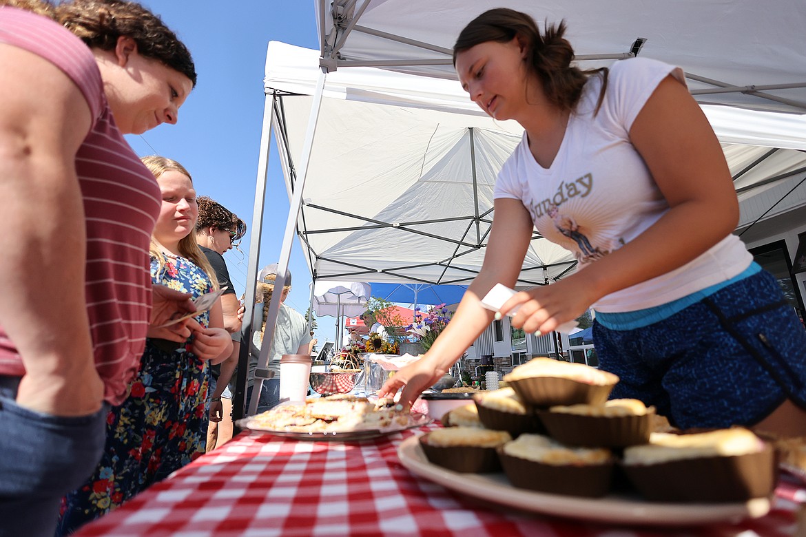 Canyon Masters describes the taste of the homemade pop tarts available at the Prairie Girl Farms booth at the new Columbia Falls Farmers Market July 31. (Jeremy Weber/Daily Inter Lake)
