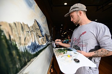 Artist Madison Apple works on a Lake Josephine painting at Bias Brewing in Kalispell for the Kalispell Downtown Association and KALICO Art Center's Downtown Art Challenge featuring historical renditions of Clarence Rundell murals on Saturday, Aug. 27. Ten artists each referenced a different Clarence Rundell mural that Rundell painted in 1936 in what is now Rocky Mountain Outfitter on Main Street in Kalispell. The paintings will be hung up and on view in  several downtown businesses from Aug. 31 to Sept. 8, during which time all of the paintings will be up for auction on the following online platform: https://app.galabid.com/kdachallenge/items. (Casey Kreider/Daily Inter Lake)