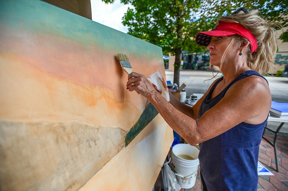 Artist Susan Guthrie works on a rendition of a Clarence Rundell mural for the Kalispell Downtown Association and KALICO Art Center's Downtown Art Challenge on Saturday, Aug. 27. Ten artists each referenced a different Clarence Rundell mural that Rundell painted in 1936 in what is now Rocky Mountain Outfitter on Main Street in Kalispell. The paintings will be hung up and on view in  several downtown businesses from Aug. 31 to Sept. 8, during which time all of the paintings will be up for auction on the following online platform: https://app.galabid.com/kdachallenge/items. (Casey Kreider/Daily Inter Lake)