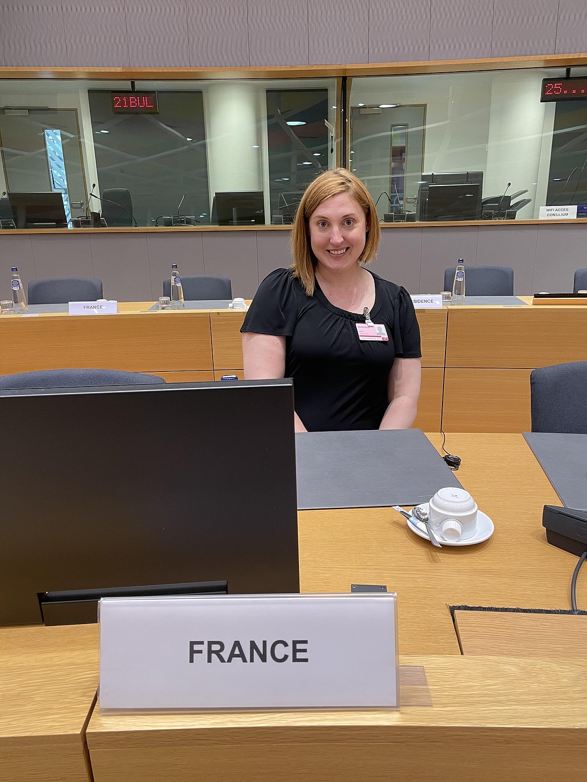 Columbia Falls High School English and French teacher Jeanette Price sits in the European Council chamber on June 20 during a study trip to Belgium. She is seated where aides to the president of France, Emmanuel Macron, would sit on June 23 when the council granted Ukraine candidate member status to the European Union. Interpretation booths are located in the background. (Photo courtesy of Jeanette Price)