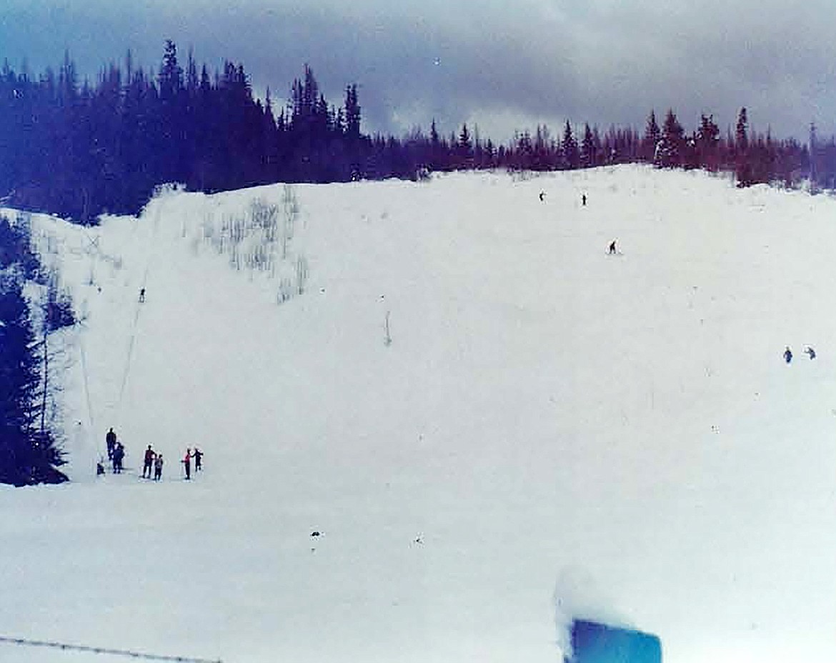 Skiers line up to take their turn on an old rope contraption to take them to the top of a ski hill that once had its home on the Pine Street Hill.