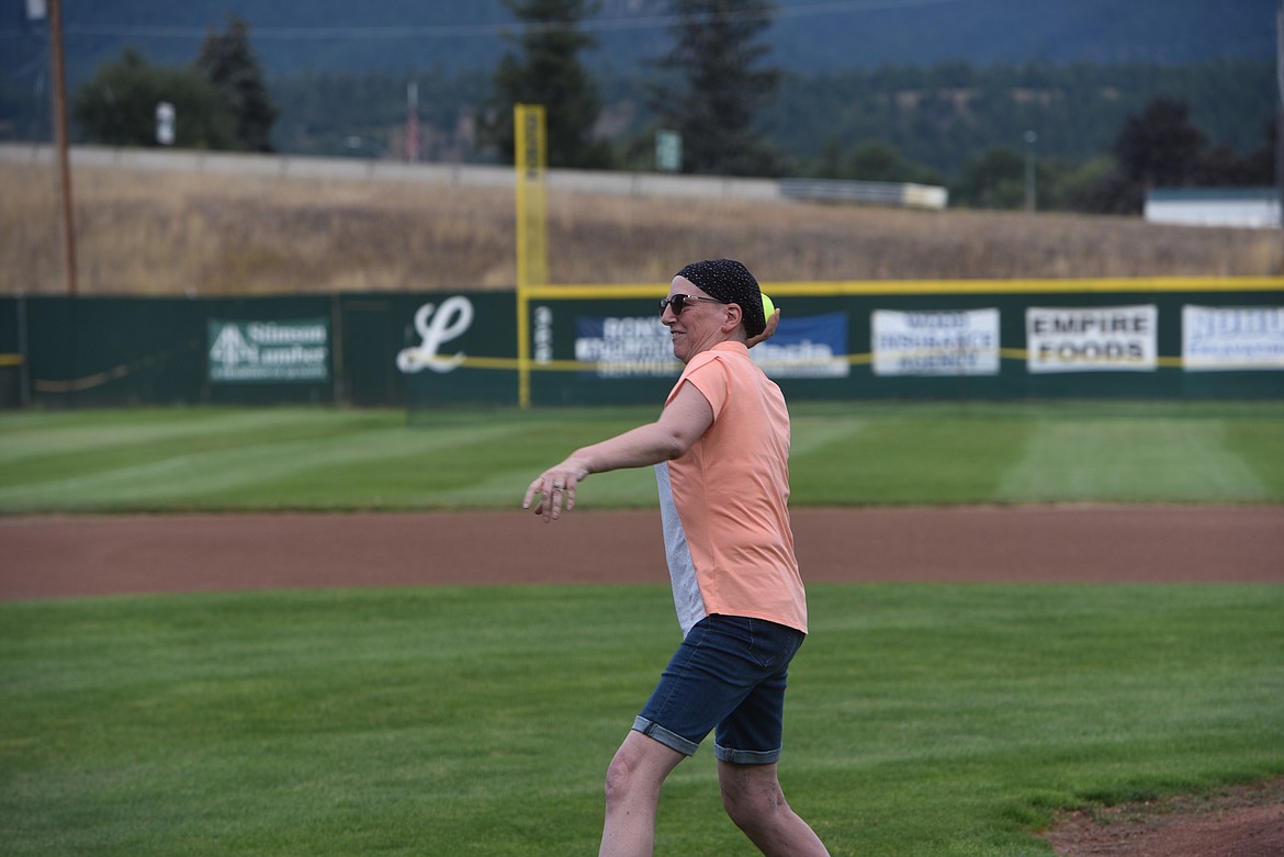 Libby Central School Special Services Secretary Carol Oedewaldt throws at the first pitch at the Fifth Annual Guns and Hoses benefit game on Thursday, Aug. 25. Oedewaldt was diagnosed with breast cancer in May. She said she was undergoing her last chemotherapy treatment this week. (Scott Shindledecker/The Western News)