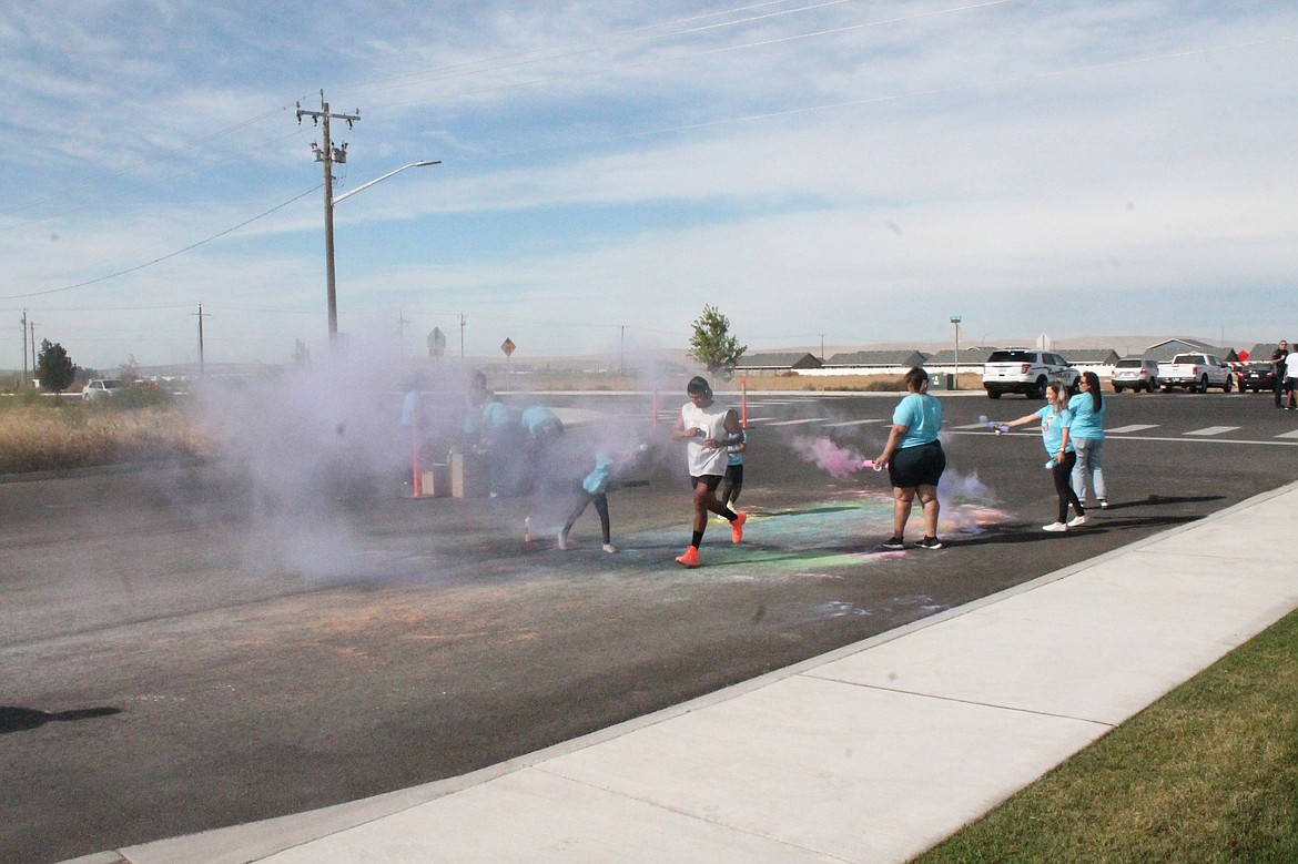A runner nears the finish line in a cloud of color at the Columbia Basin Health Association’s Color Run Saturday.