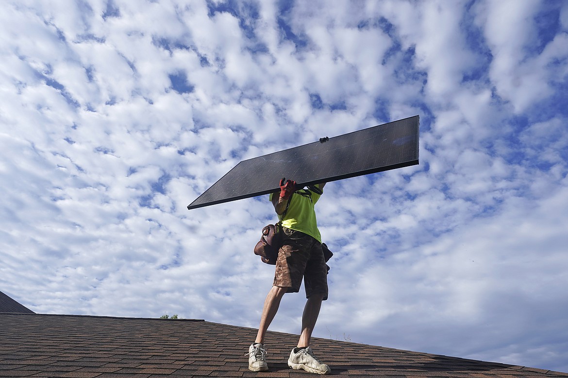 A workman from Power Shift Solar installs a solar panel Thursday, Aug. 11, 2022, in Salt Lake City. (AP Photo/Rick Bowmer)