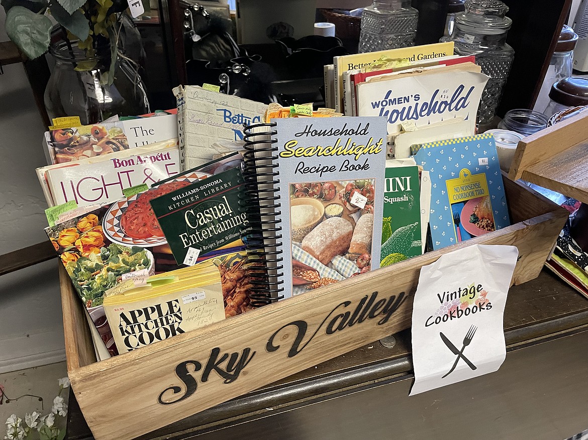 A wooden crate full of old cookbooks, complete with bookmarks and notes left over from the original owners, for sale at The Favored Farmhouse.
